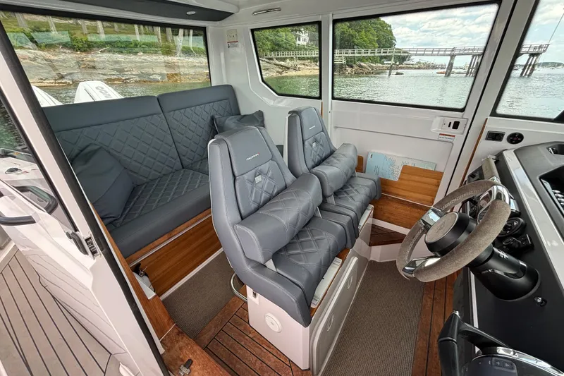 Slide: The Image of Interior of 2021 Axopar 28 Cabin boat with plush seating and scenic water view. - 14