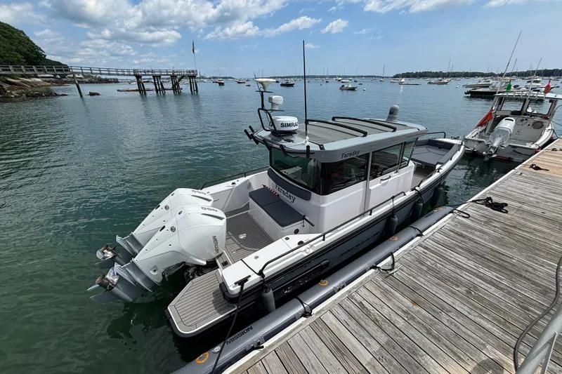 Slide: The Image of 2021 Axopar 28 Cabin boat docked by a wooden pier on a sunny day. - 4