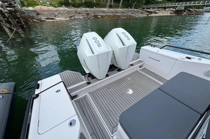 Slide: The Image of 2021 Axopar 28 Cabin boat with twin Mercury outboard engines on a calm waterway. - 8
