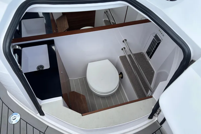 Slide: The Image of 2021 Axopar 28 Cabin boat interior with compact bathroom and sink. - 18