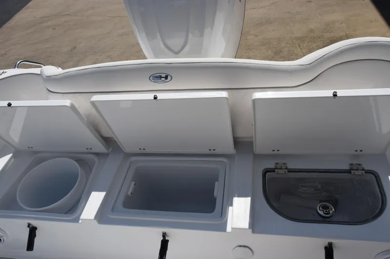 Slide: The Image of 2027 Sea Hunt Ultra 255 SE boat storage compartments with open lids, showcasing interior space. - 16