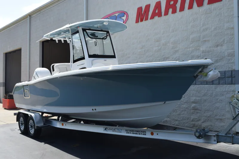 Slide: The Image of 2027 Sea Hunt Ultra 255 SE boat on trailer outside marine dealership. - 2