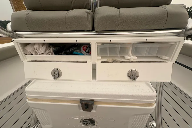 Slide: The Image of 2023 Sportsman Masters 227 Bay Boat storage compartments with seating and cooler. - 17