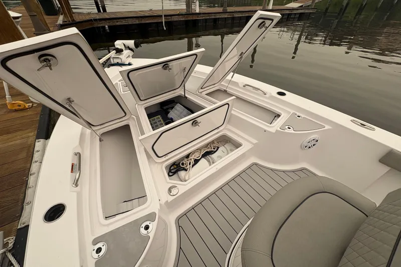 Slide: The Image of 2023 Sportsman Masters 227 Bay Boat with open storage compartments at dockside. - 11