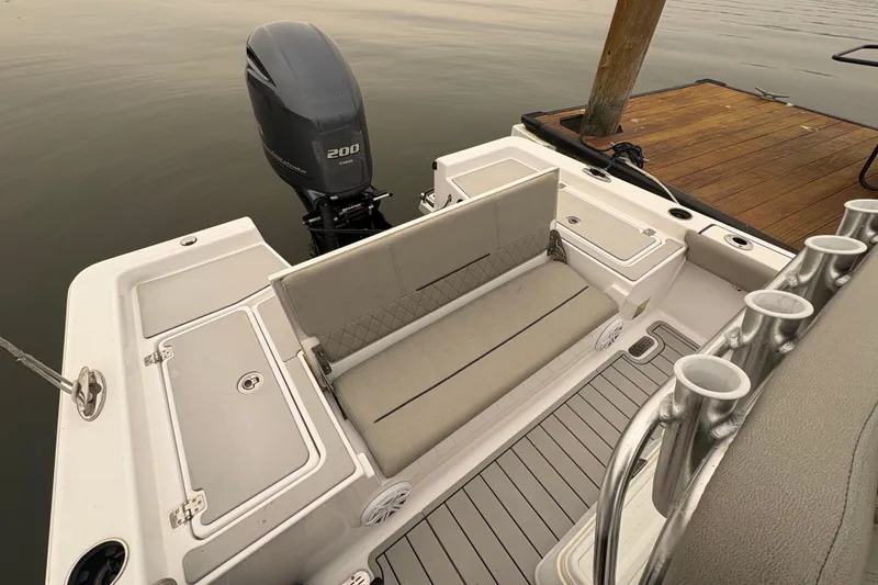 Slide: The Image of 2023 Sportsman Masters 227 Bay Boat with Yamaha 200 engine, docked, featuring seating and rod holders. - 15