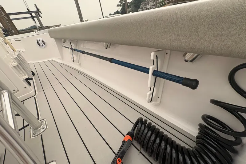 Slide: The Image of 2023 Sportsman Masters 227 Bay Boat interior with rod holder and coiled hose. - 19