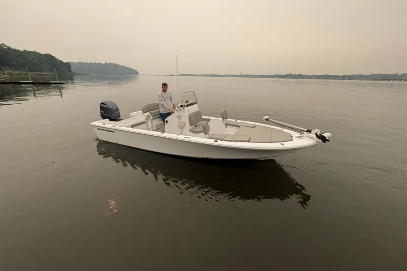 Slide: The Image of 2023 Sportsman Masters 227 Bay Boat on calm water with a person at the helm. - 5
