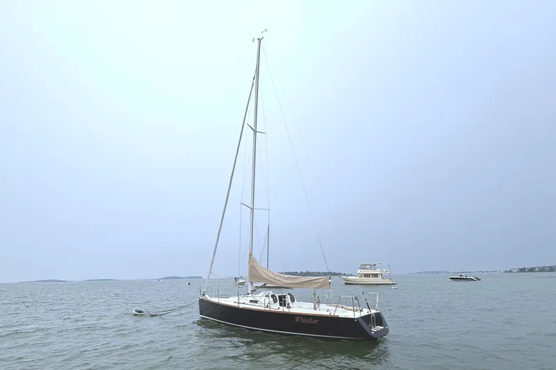 Slide: The Image of A 2006 J/100 sailboat rests calmly on the water, surrounded by other boats. - 13