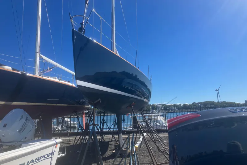 Slide: The Image of 2006 J Boats J/100 sailboat on stands, marina background, clear blue sky. - 9