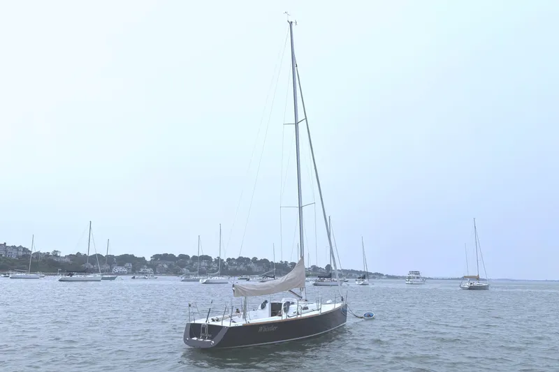 Slide: The Image of A 2006 J/100 sailboat is anchored in a calm harbor with several other boats. - 12
