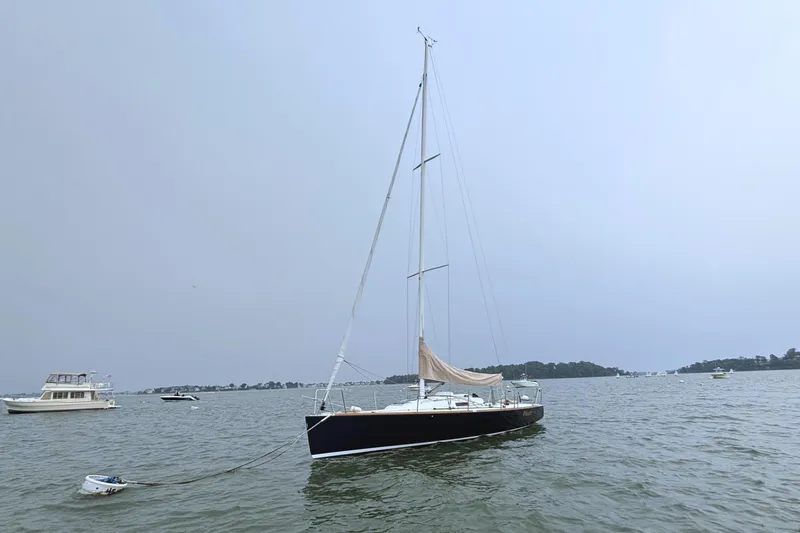 Slide: The Image of Sailboat J/100 from 2006 by J Boats moored on a calm waterway. - 10