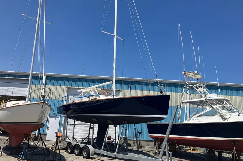 Slide: The Image of 2006 J Boats J/100 sailboat on trailer in boatyard under clear blue sky. - 6
