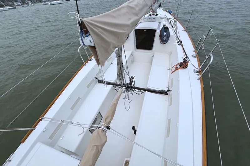 Slide: The Image of The image shows the deck of a 2006 J/100 with sail and rigging. - 14