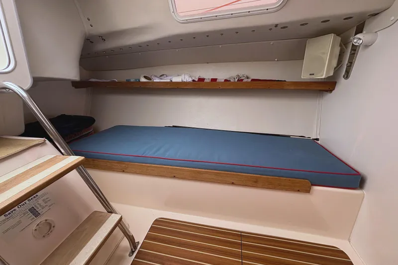 Slide: The Image of Interior cabin of 2006 J Boats J/100 with blue cushion and wooden accents. - 26
