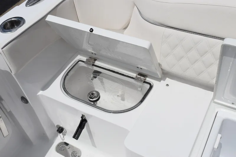 Slide: The Image of Open storage compartment on 2027 Sea Hunt Ultra 275 SE boat with white seating. - 22