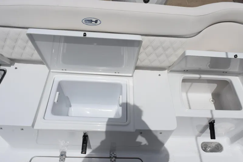 Slide: The Image of 2027 Sea Hunt Ultra 275 SE boat with open storage compartments and cushioned seating. - 23
