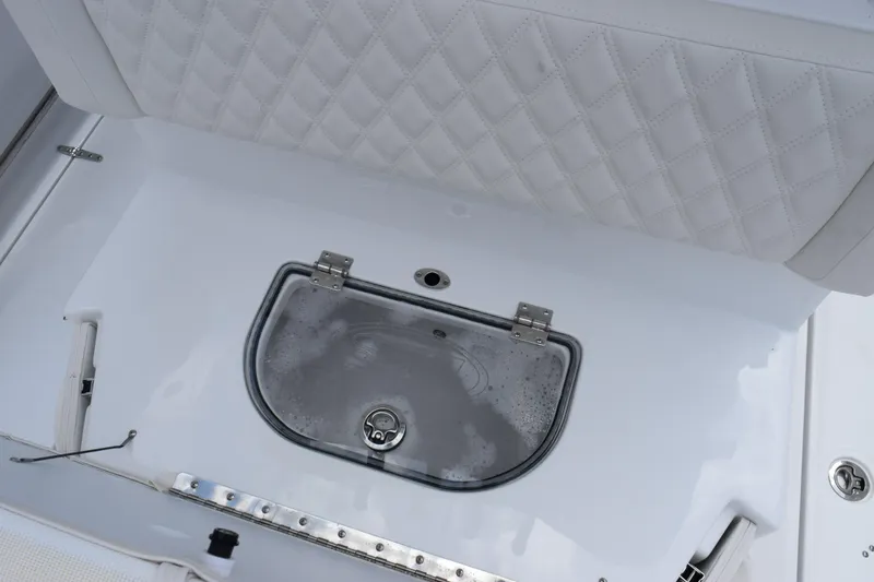 Slide: The Image of 2027 Sea Hunt Ultra 275 SE boat interior with cushioned seating and storage compartment. - 21