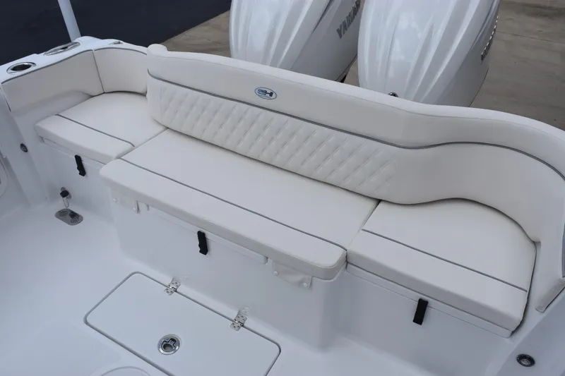 Slide: The Image of 2027 Sea Hunt Ultra 275 SE boat seating area with white cushioned bench and storage compartments. - 6