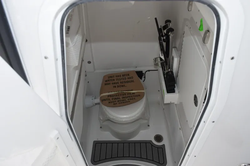 Slide: The Image of Interior of 2027 Sea Hunt Ultra 275 SE boat bathroom with toilet and protective film. - 14