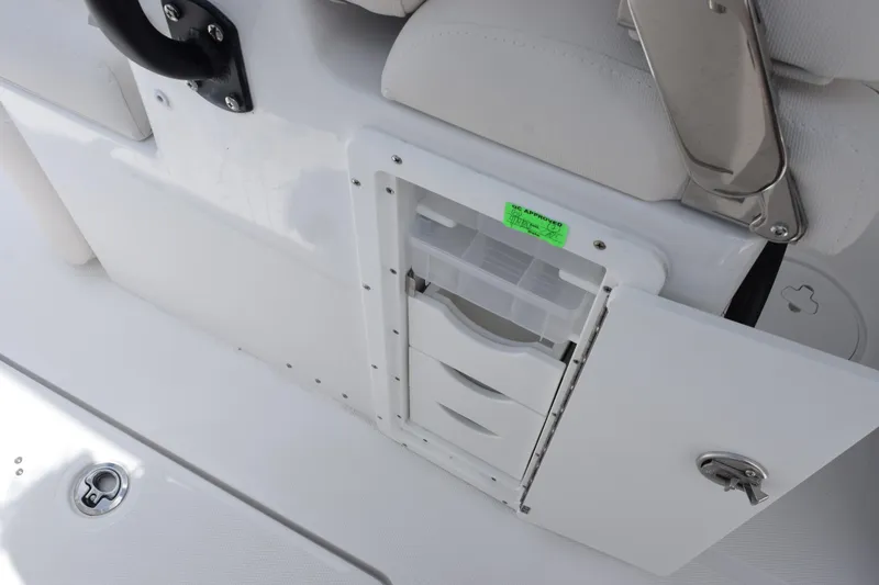 Slide: The Image of Storage compartment on 2027 Sea Hunt Ultra 275 SE boat, featuring organized drawers and secure latch. - 19