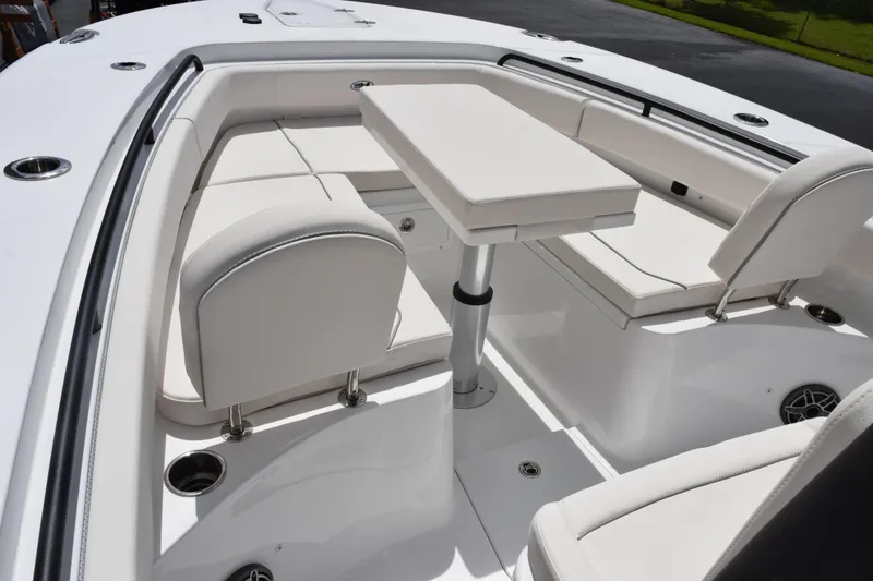 Slide: The Image of 2027 Sea Hunt Ultra 275 SE boat interior with white seating and adjustable table. - 11