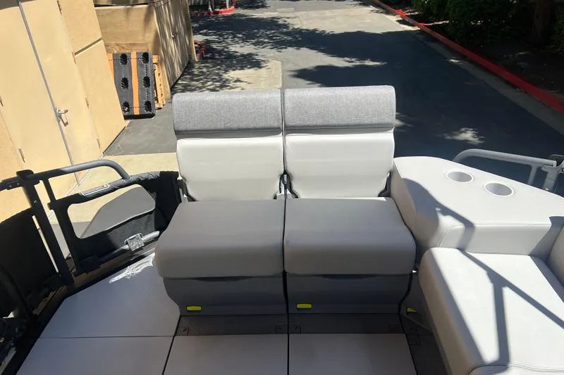 Slide: The Image of 2026 Sea-Doo Switch Cruise 21 interior seating with cup holders, parked outdoors. - 10