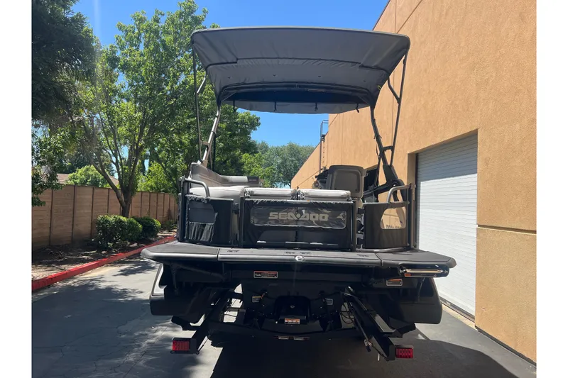 Slide: The Image of 2026 Sea-Doo Switch Cruise 21 pontoon boat parked outdoors, rear view. - 5