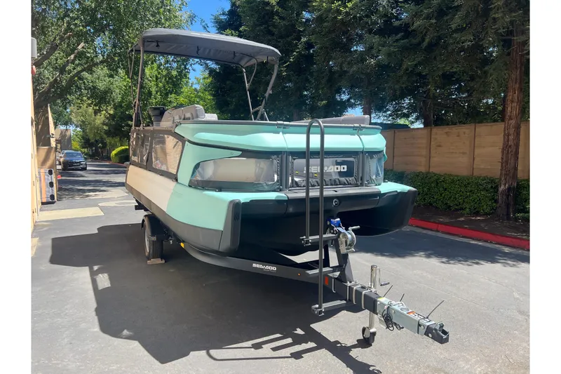 Slide: The Image of 2026 Sea-Doo Switch Cruise 21 on trailer, parked outdoors, surrounded by trees. - 1