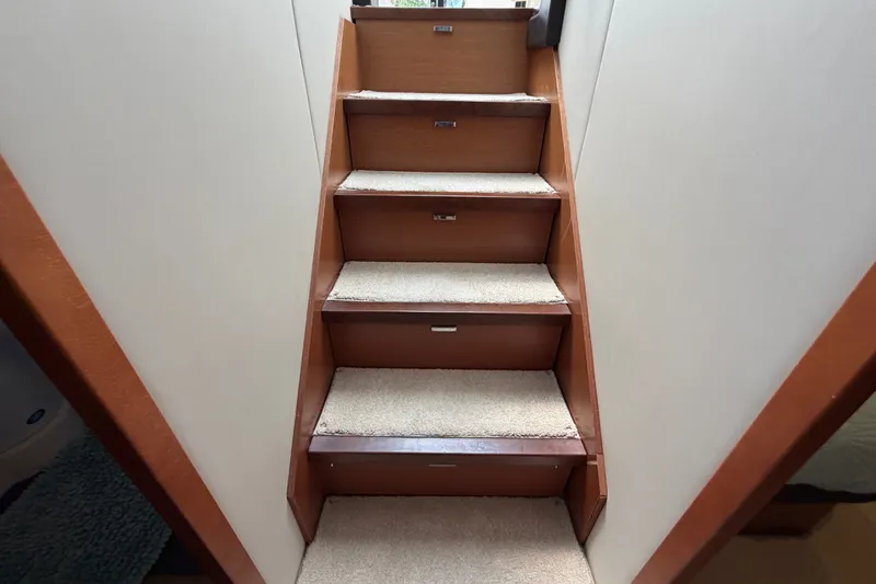 Slide: The Image of Carpeted stairs inside a 2012 Prestige 500S yacht, featuring wooden accents. - 47