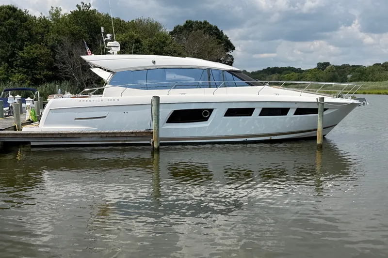 The Image of Luxury 2012 Prestige 500S yacht docked on a serene river under cloudy skies. - 0