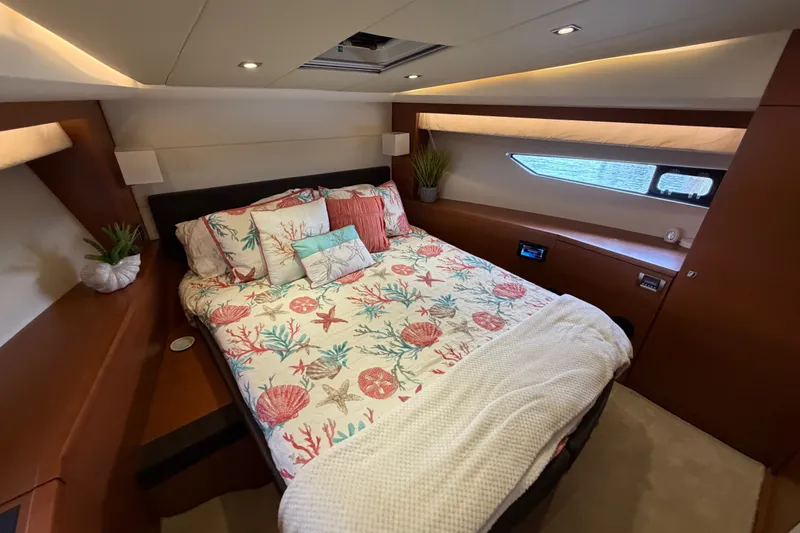 Slide: The Image of The 2012 Prestige 500S cabin features a cozy bed with nautical-themed bedding. - 45