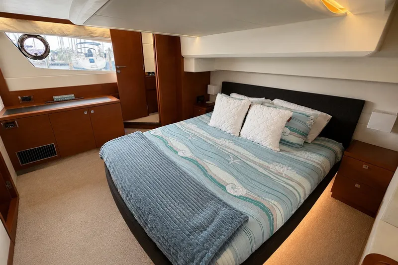 Slide: The Image of Luxurious bedroom interior of a 2012 Prestige 500S yacht with elegant bedding and wood accents. - 56