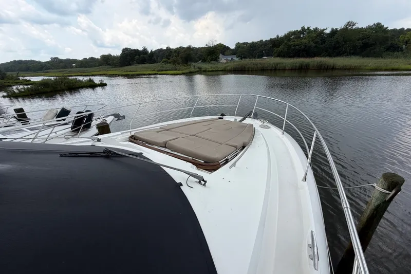 Slide: The Image of Prestige 500S yacht (2012) docked by a serene riverbank with lush greenery. - 86