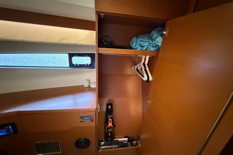 Slide: The Image of Open wooden closet in 2012 Prestige 500S yacht interior with hangers and folded clothes. - 72