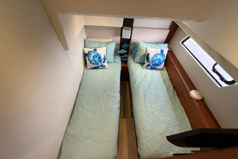 Slide: The Image of Twin beds with sea turtle pillows in a 2012 Prestige 500S yacht cabin. - 49