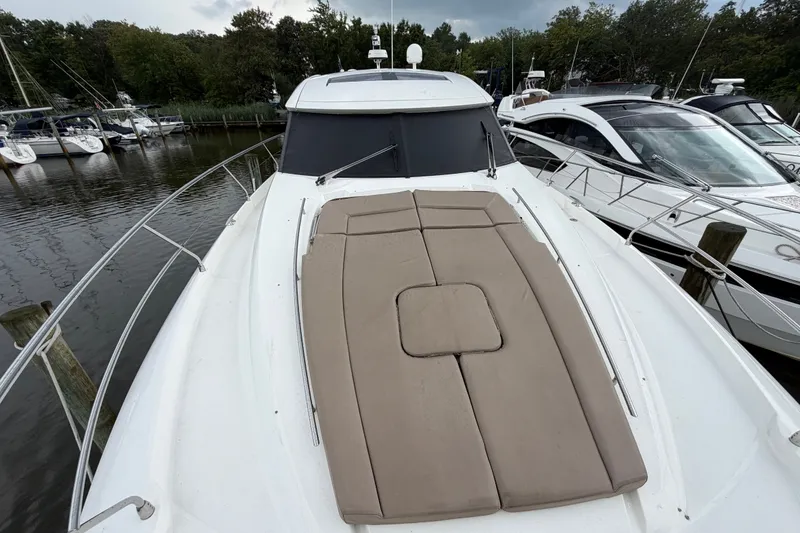 Slide: The Image of 2012 Prestige 500S yacht with sunpad, docked in a marina surrounded by trees. - 87