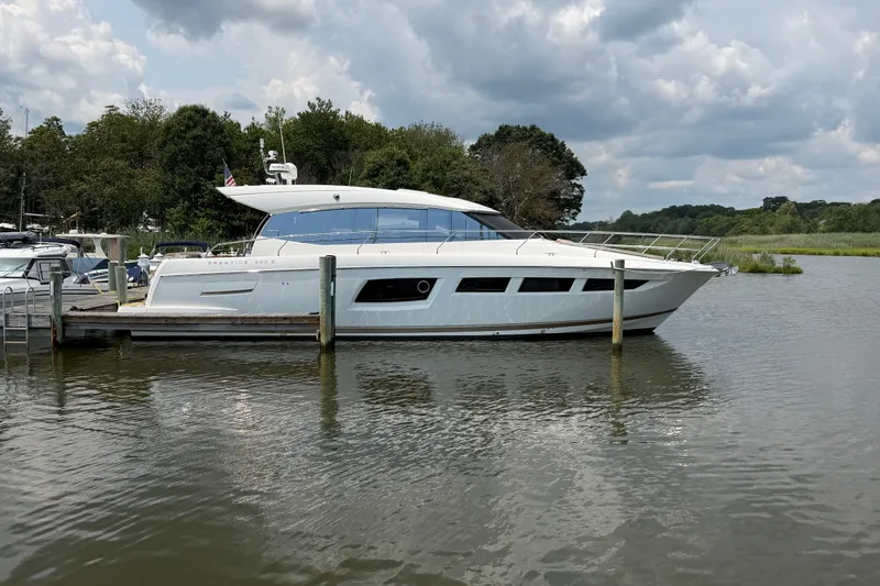 Slide: The Image of Luxury 2012 Prestige 500S yacht docked on a serene river under cloudy skies. - 1
