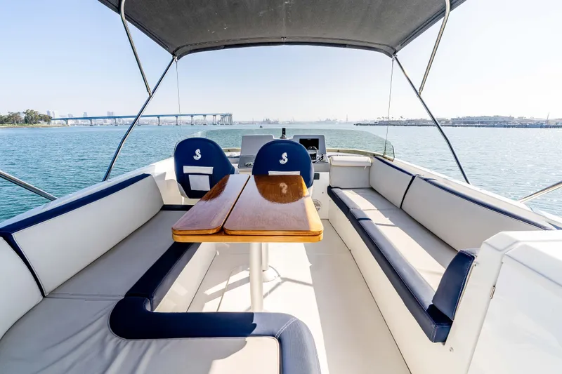 Slide: The Image of 2019 Beneteau Swift Trawler 44 interior with seating and table, overlooking scenic water view. - 10