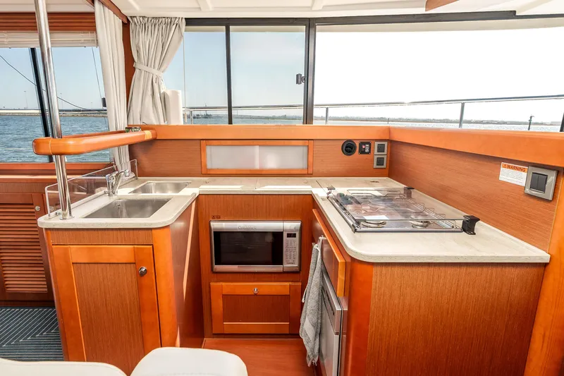 Slide: The Image of Interior of 2019 Beneteau Swift Trawler 44 kitchen with wood cabinetry and modern appliances. - 21