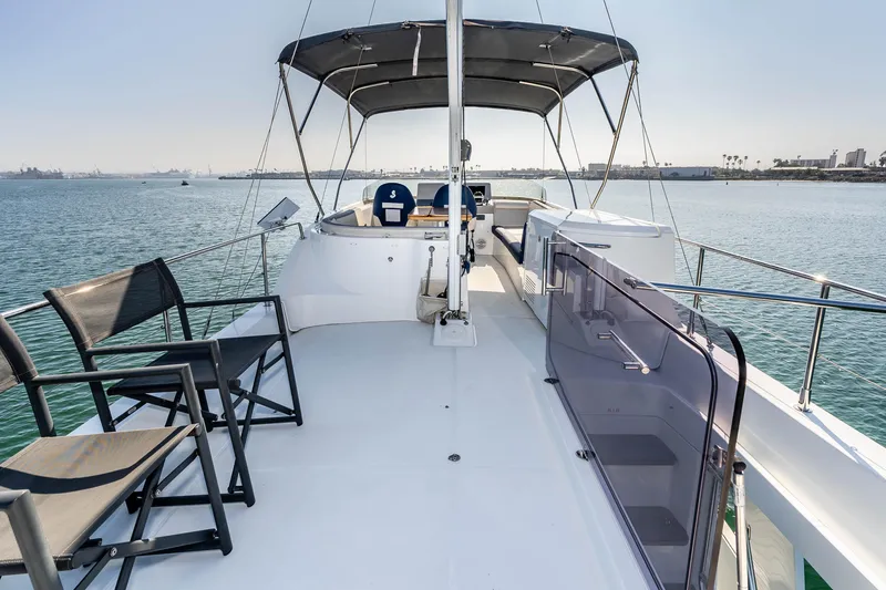 Slide: The Image of 2019 Beneteau Swift Trawler 44 flybridge with seating, overlooking calm waters. - 8