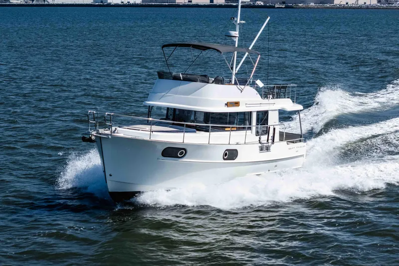 Slide: The Image of 2019 Beneteau Swift Trawler 44 cruising on open water, showcasing sleek design and performance. - 2