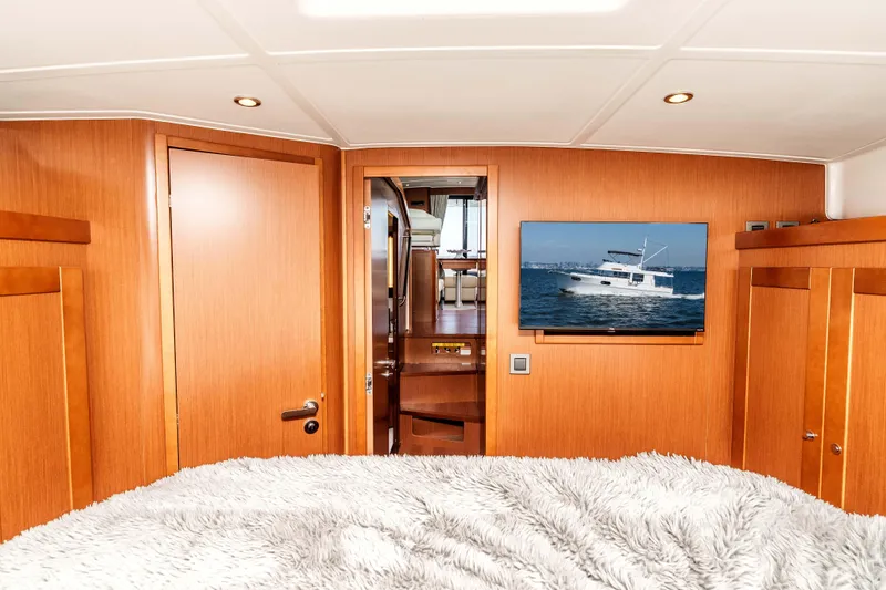 Slide: The Image of Luxurious interior of 2019 Beneteau Swift Trawler 44 with wood paneling and TV display. - 26