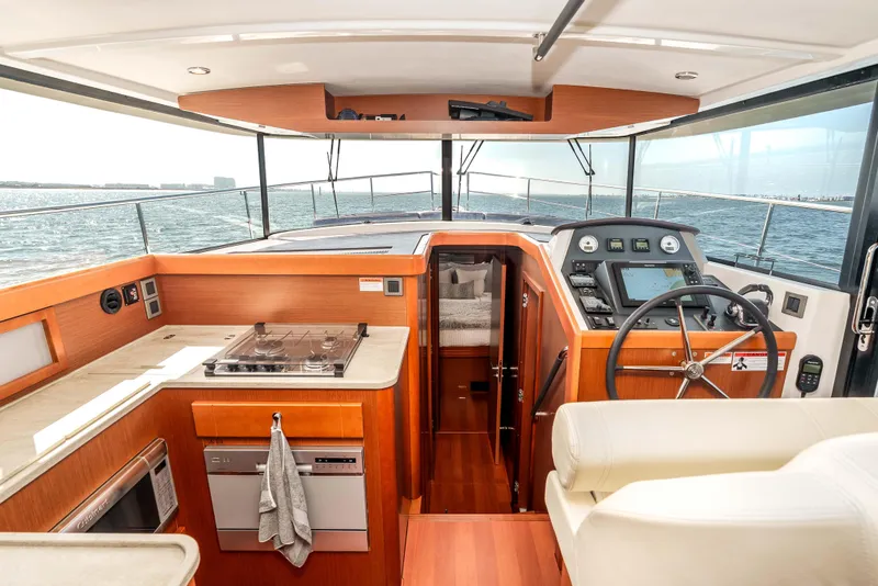 Slide: The Image of Interior view of 2019 Beneteau Swift Trawler 44, featuring helm and kitchen area. - 20