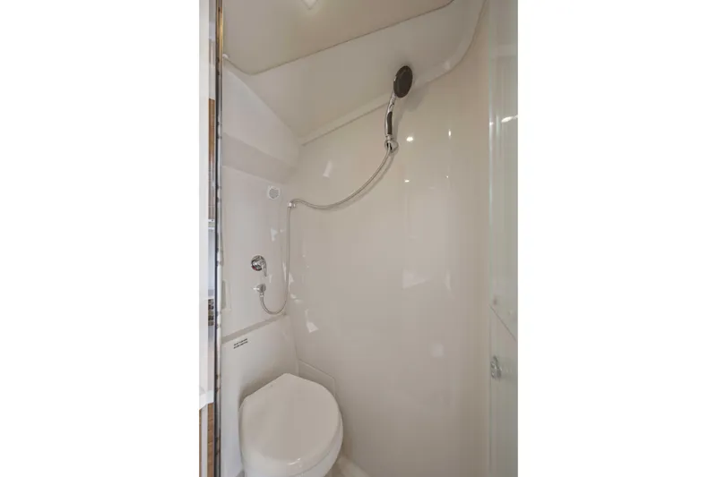 Slide: The Image of Bathroom interior of 2016 Cruisers Yachts 45 Cantius, featuring a compact shower and toilet. - 57