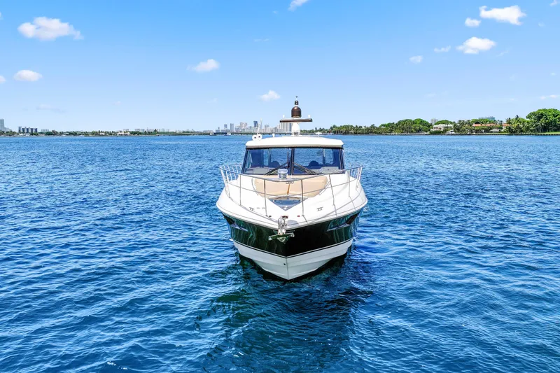 Slide: The Image of 2016 Cruisers Yachts 45 Cantius on serene blue water with city skyline backdrop. - 2