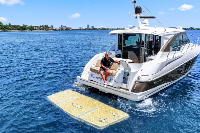 Slide: The Image of 2016 Cruisers Yachts 45 Cantius on water, person relaxing on swim platform. - 17