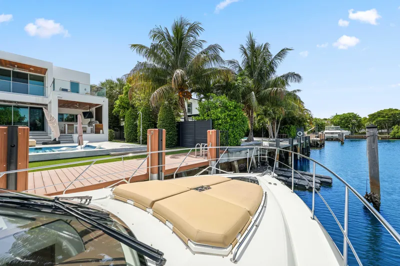 Slide: The Image of 2016 Cruisers Yachts 45 Cantius docked by luxurious waterfront home with palm trees. - 61