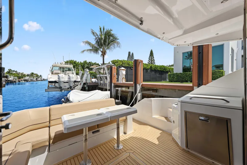 Slide: The Image of 2016 Cruisers Yachts 45 Cantius docked, featuring spacious deck and luxurious seating area. - 26