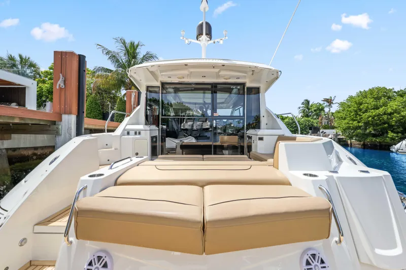 Slide: The Image of 2016 Cruisers Yachts 45 Cantius with spacious deck and luxurious seating, docked by lush greenery. - 19