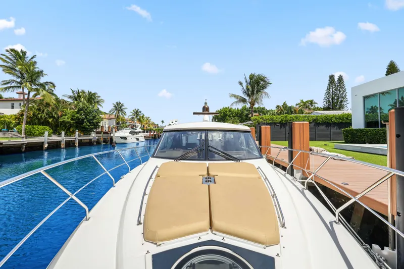 Slide: The Image of 2016 Cruisers Yachts 45 Cantius docked by a scenic waterfront with palm trees. - 60